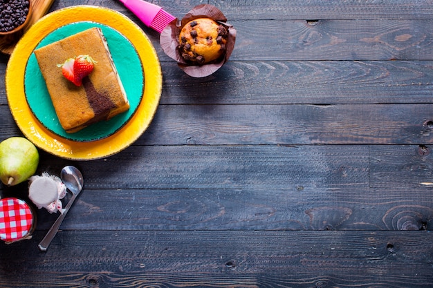 Faccia colazione con differenti pasticcini e frutti su un di legno