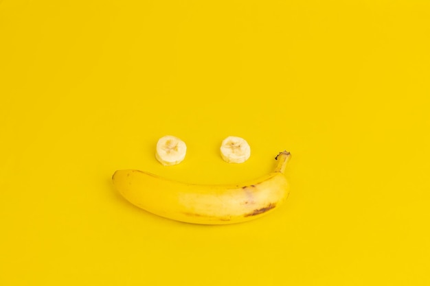 faccia felice fatta con banana su sfondo giallo
