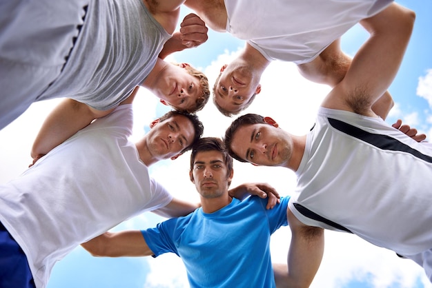 Facciamo questo Ripresa di un gruppo di giovani sportivi in forma in piedi in una rannicchiata