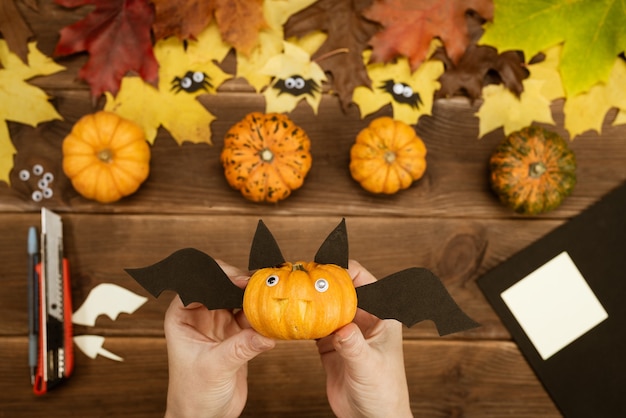 Facciamo regali per Halloween. Fare un pipistrello divertente con una piccola zucca gialla. Decorazioni per feste di Halloween. Istruzioni fai da te. Guida passo passo.