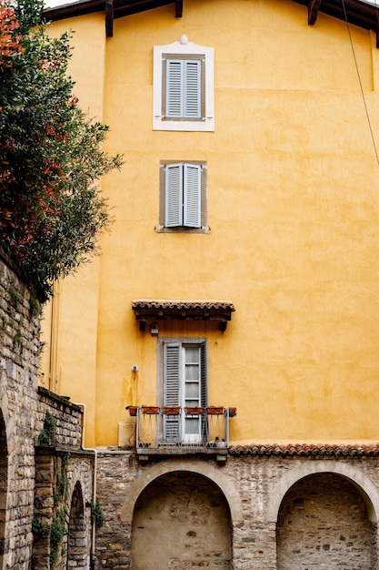 Facciata arancione di una vecchia casa con archi bergamo italia