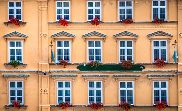 Facciata d'epoca con finestre e fiori rossi a Krumlov