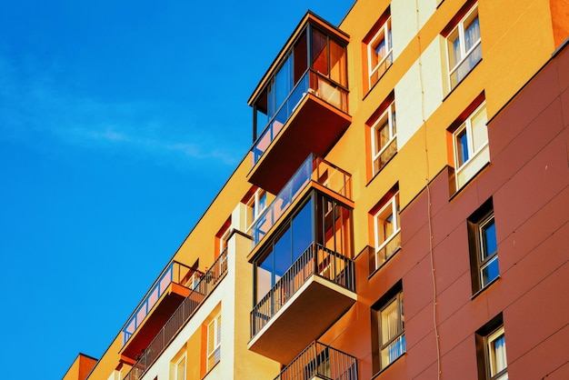 Facciata di un condominio residenziale e un posto vuoto per lo spazio della copia. Cielo azzurro sullo sfondo.