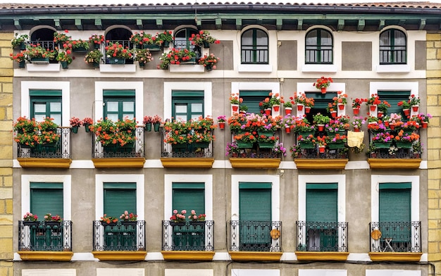 Facciata di una casa con balconi pieni di fiori nella città di Hondarribia nei Paesi Baschi. Spagna.