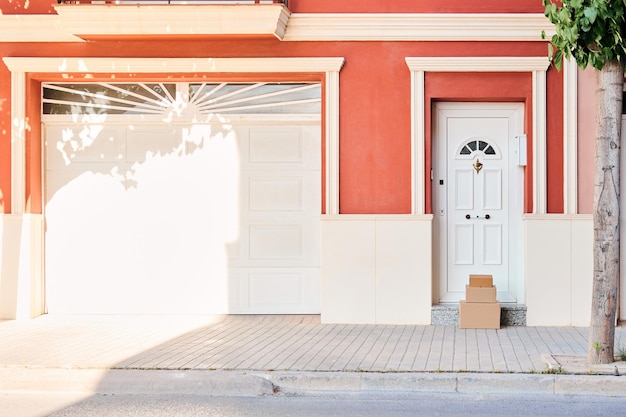 Facciata di una casa di colore arancione con scatole di cartone sulla porta