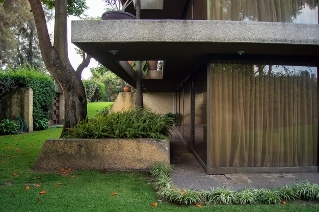 Facciata di una casa moderna con fiocco in pietra che avvolge le finestre verniciate in metallo grigio ferro d'ingresso