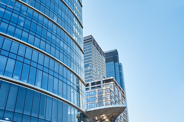 Facciata di vetro del grattacielo di architettura moderna della città con l'edificio amministrativo di affari dell'albero verde