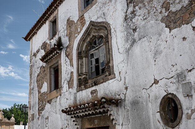 Facciata edificio in rovina con finestre rotte