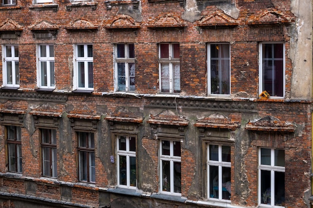 Facciata pesantemente distrutta di una casa di mattoni fatiscente edificio residenziale edificio a più piani di emergenza