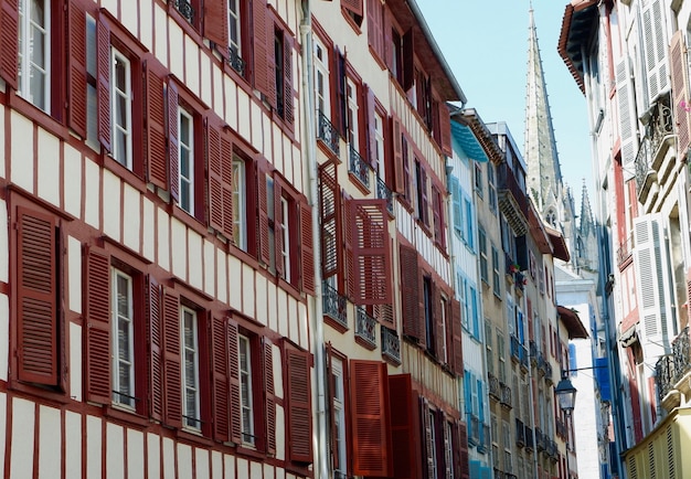 Facciate vivaci di edifici baschi classici sulla strada stretta e accogliente a Bayonne in Francia