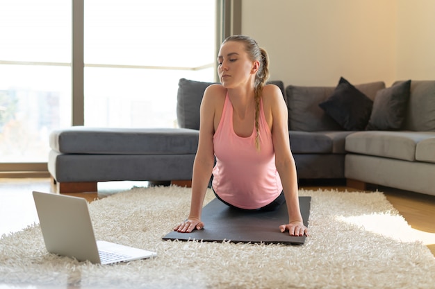 facendo esercizi di yoga davanti al computer portatile