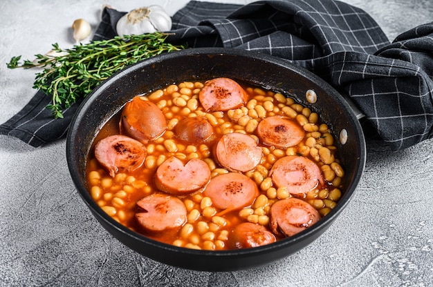 Fagioli con salsicce in salsa di pomodoro in padella.