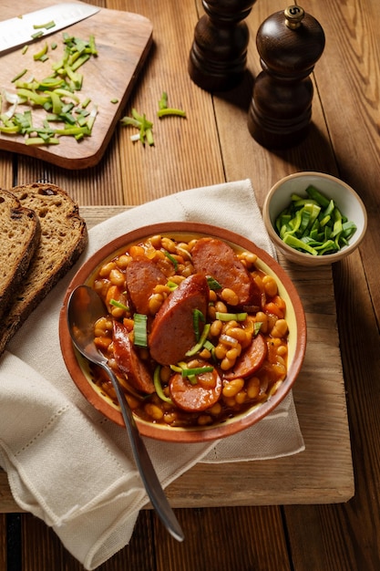 Fagioli con salsiccia e salsa di pomodoro Stufato di fagioli cucina inglese rustica fatta in casa Fondo di legno rustico