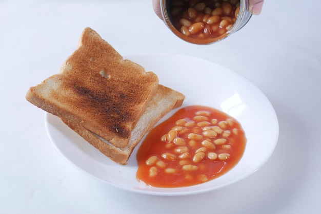 Fagioli conservati versando da un contenitore di latta su un piatto