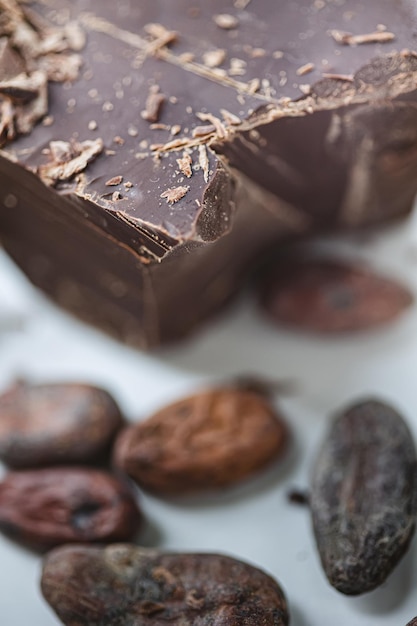 Fagioli di cacao con cioccolato su uno sfondo bianco Shalllow dof