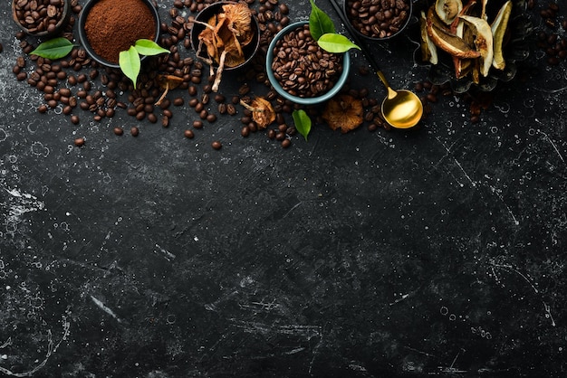 Fagioli di caffè profumati e funghi secchi su uno sfondo di pietra nera Superfood alimentare biologico Vista superiore Spazio libero per il testo