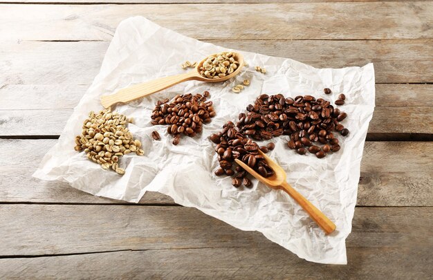 Fagioli di caffè su pergamena arrugginita su un tavolo di legno