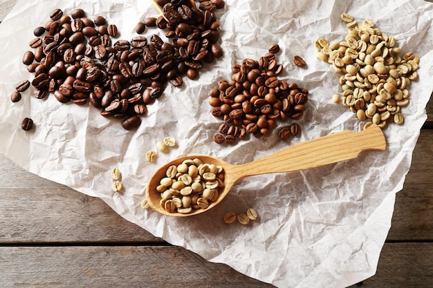 Fagioli di caffè su pergamena arrugginita su un tavolo di legno