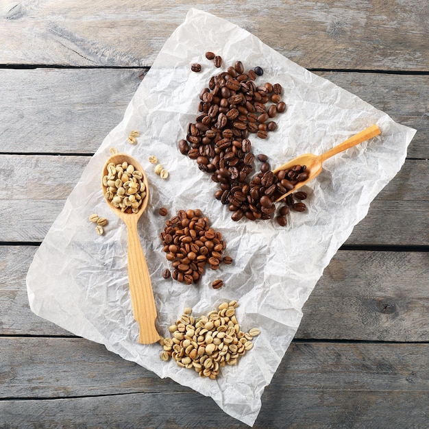 Fagioli di caffè su pergamena arrugginita su una tavola di legno