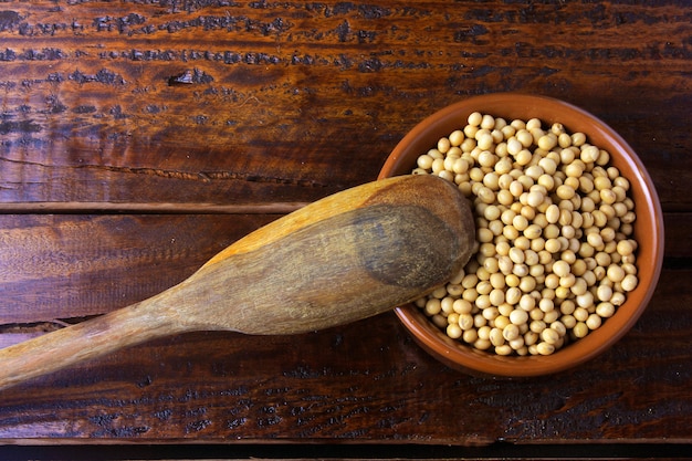 Fagioli di soia crudi e freschi all&#39;interno ciotola in ceramica bianca sul tavolo in legno rustico