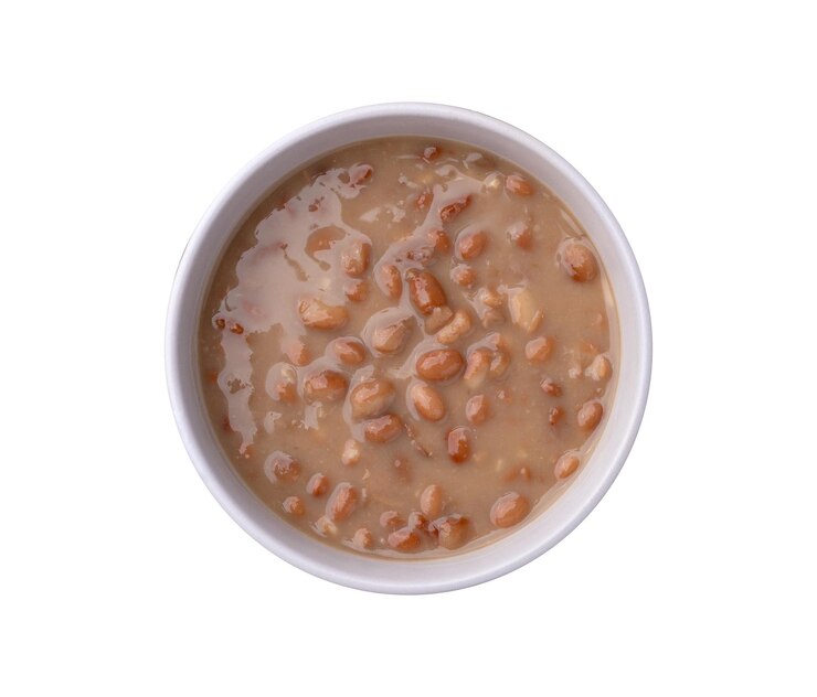 Fagioli marroni cotti in una ciotola isolati su uno sfondo bianco