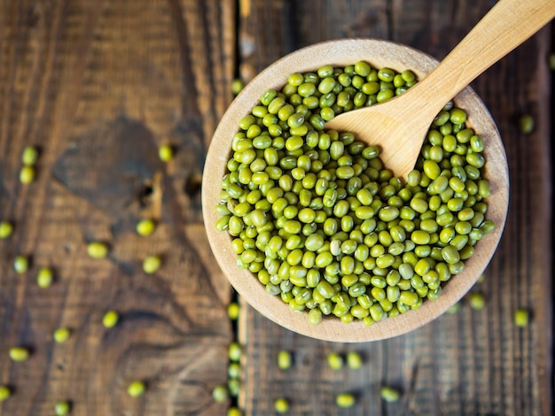 Fagioli verdi crudi in una ciotola su una vecchia tavola di legno pianta leguminosa per una dieta sana