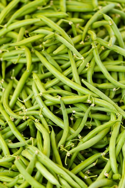 Fagiolini freschi in un mucchio al mercato agricolo locale.