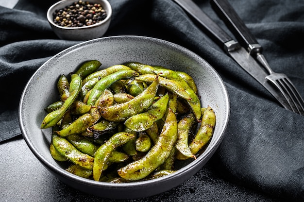 Fagiolo edamame cotto a vapore, soia verde in una padella, cucina asiatica orientale. Sfondo bianco. Vista dall'alto