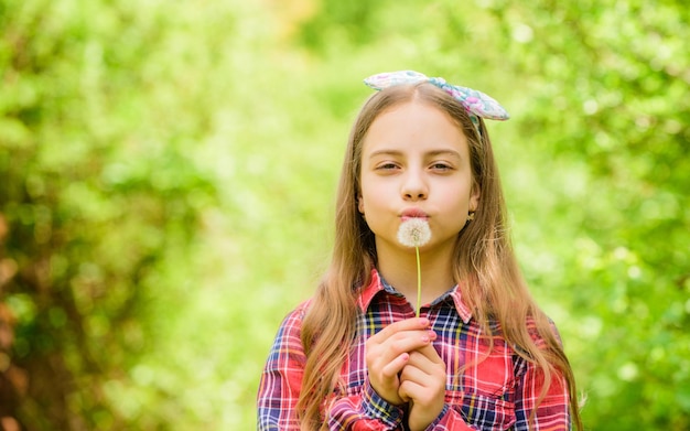 Fai un desiderio Ragazza adolescente vestita in stile rurale camicia a scacchi sfondo naturale Celebrando il ritorno dell'estate Dandelion è bello e pieno di simbolismo L'estate è qui Fiore del giardino estivo