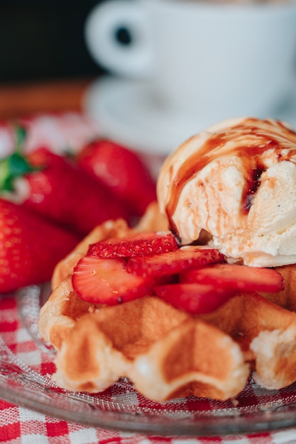 Fai uno spuntino su una cialda con gelato e frutta ricoperta di sciroppo al caramello. Copia spazio