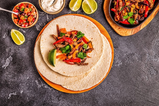 FAJITAS con peperoni colorati e cipolle servite con tortillas