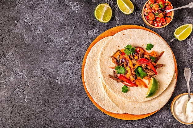 FAJITAS con peperoni colorati e cipolle servite con tortillas