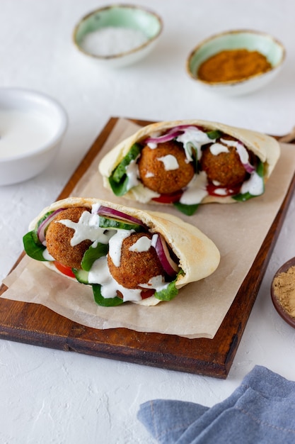 Falafel in pita con pomodori, cetrioli, cipolle e spinaci. Mangiare sano. Cibo vegetariano.