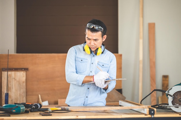Falegname che lavora con attrezzature su tavola di legno in officina del legno uomo che fa lavori in legno in falegnameria