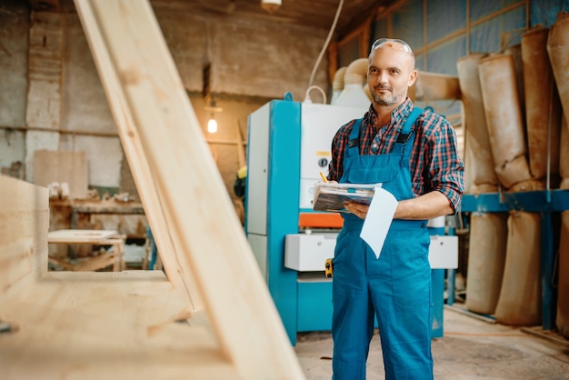 Falegname con notebook, lavorazione del legno, fabbrica