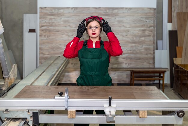 Falegname donna vestire le cuffie di sicurezza in officina