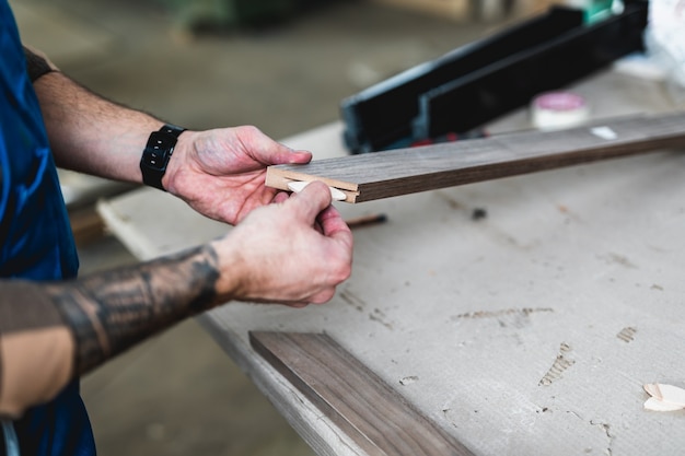 Falegname professionista concentrato che lavora nel suo laboratorio, lavorazione del legno e concetto di artigianato.