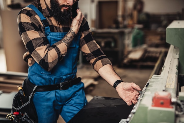 Falegname professionista concentrato che lavora nel suo laboratorio, lavorazione del legno e concetto di artigianato.