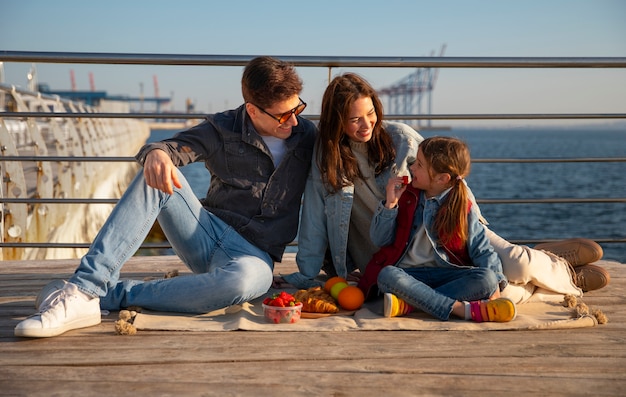 Famiglia a figura intera che va in giro su un molo