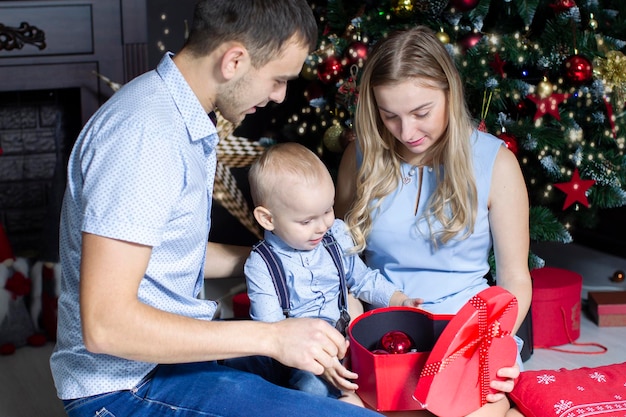 Famiglia a Natale Mamma papà e figlio all'albero di Natale