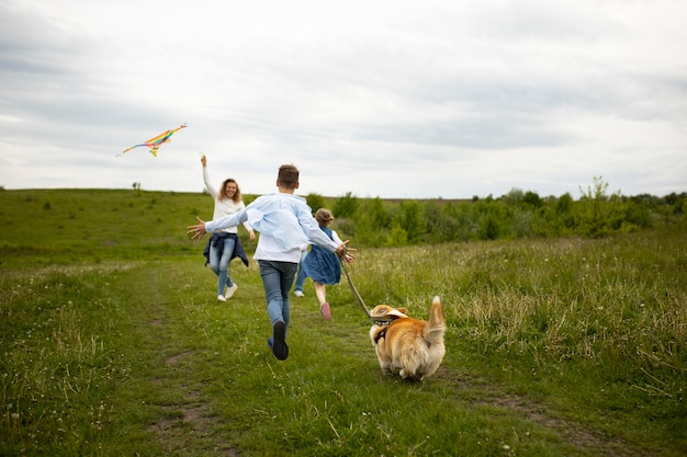 Famiglia a tutto campo che gioca con l'aquilone all'aperto