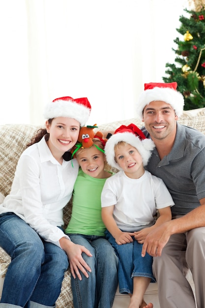 Famiglia adorabile a Natale che si siede nel salone