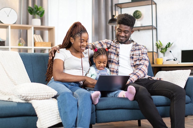 Famiglia africana che utilizza il computer portatile durante il tempo libero a casa