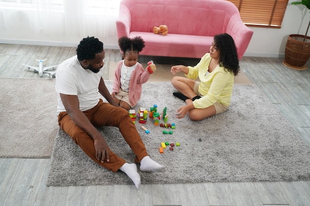Famiglia africana felice che ha tempo giocoso a casa Amore familiare Genitori e bambini al coperto