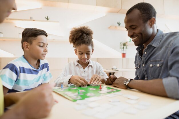 famiglia afro-americana che gioca a un gioco da tavolo nella caffetteria