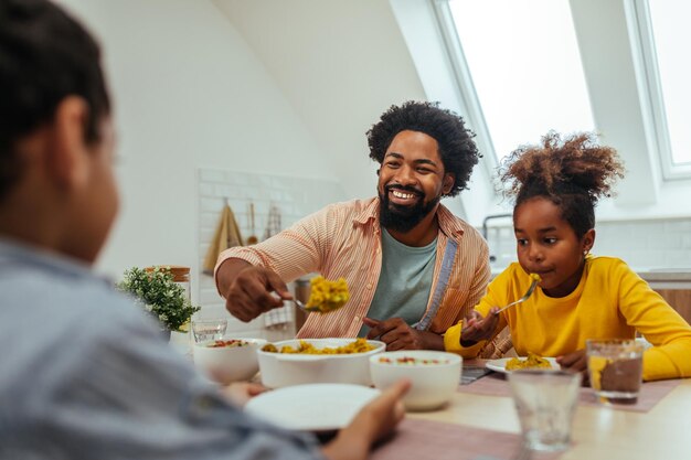 Famiglia afro carina che pranza insieme a casa