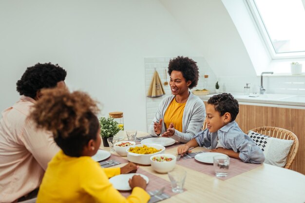 Famiglia afro carina che pranza insieme a casa