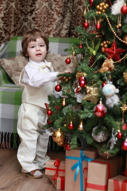 Famiglia alla vigilia di Natale al caminetto Bambini che aprono i regali di Natale Bambini sotto l'albero di Natale