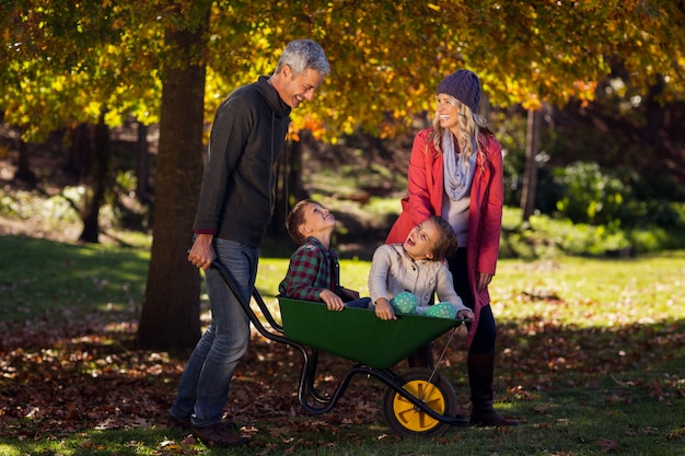 Famiglia allegra che gioca con la carriola