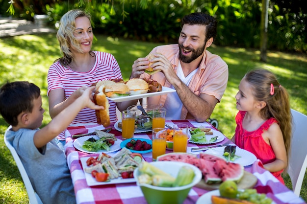 Famiglia allegra che gode del pasto nell'iarda